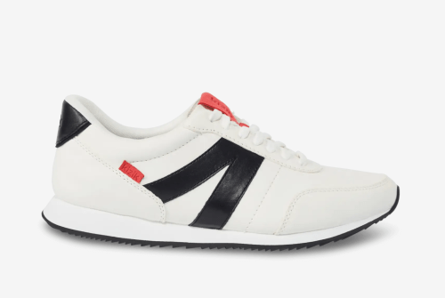 White sneakers with black accents and a red logo, featuring a classic design and lace-up closure.